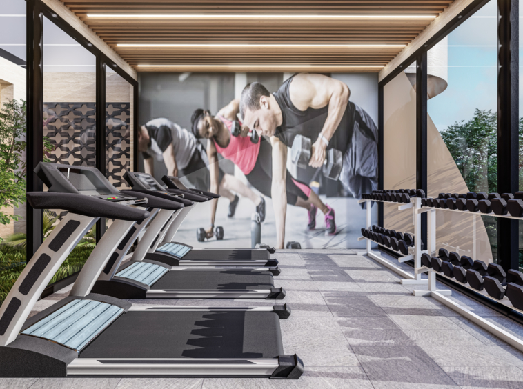 Modern gym with treadmills on the left, dumbbell racks on the right, and a large workout mural on the back wall. Outdoor greenery visible through glass walls.