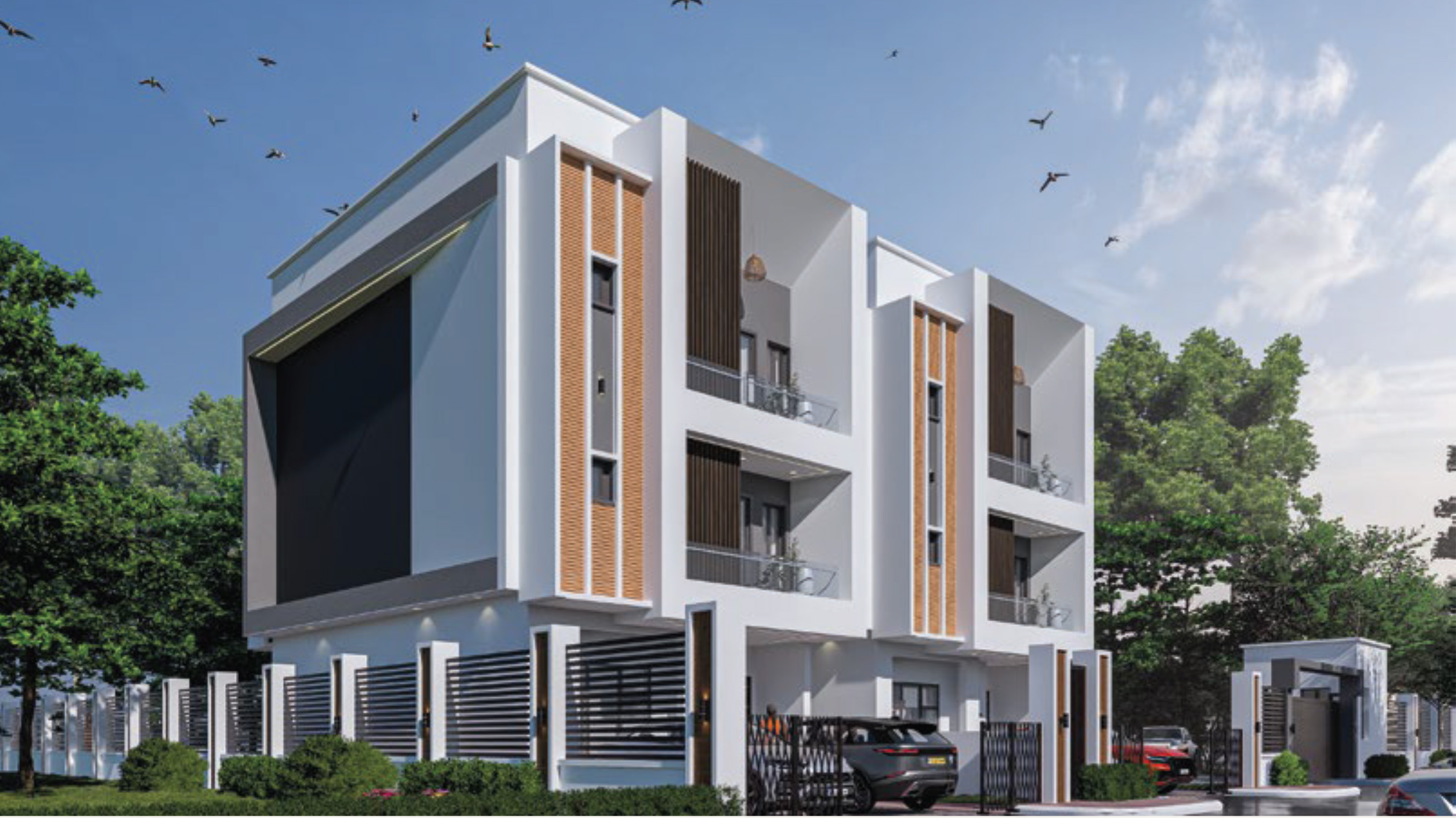 Modern white apartment building with brown brick vertical accents, balconies, and a gated entrance under a clear blue sky.